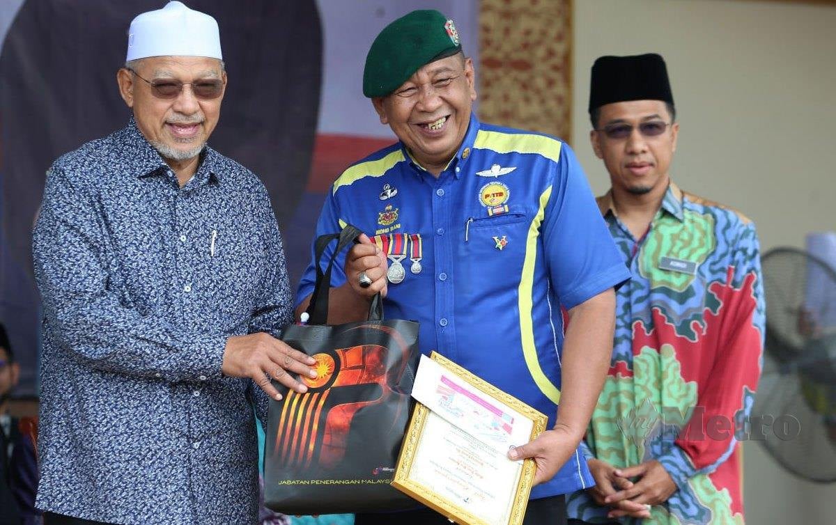DATUK Ahmad Yakob (kiri) menyampaikan sijil penghargaan kepada pejuang tanah air kepada Mohd Rani Hussin. FOTO Nik Abdullah Nik Omar