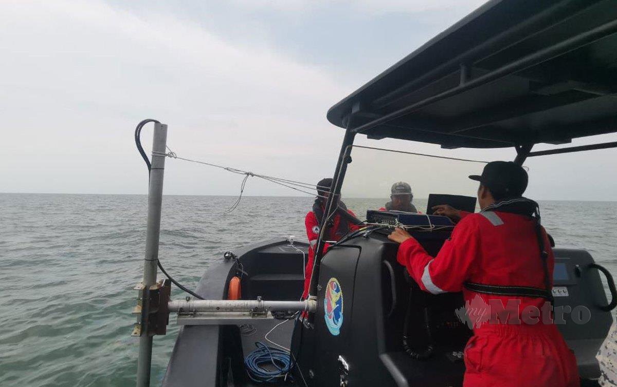 ALAT pengesan sonar diturunkan ke dalam laut bagi mengesan kedudukan tepat bot karam di perairan Parit Hailam di sini. FOTO Essa Abu Yamin