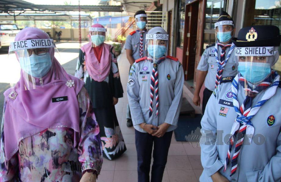 AZIZAH bersama Nor Azlin Mat Nor serta ahlinya memakai pelindung muka kepada sebagai persediaan untuk sebarang kemungkinan bagi menghadapi penularan wabak Covid-19. FOTO Nik Abdullah Nik Omar