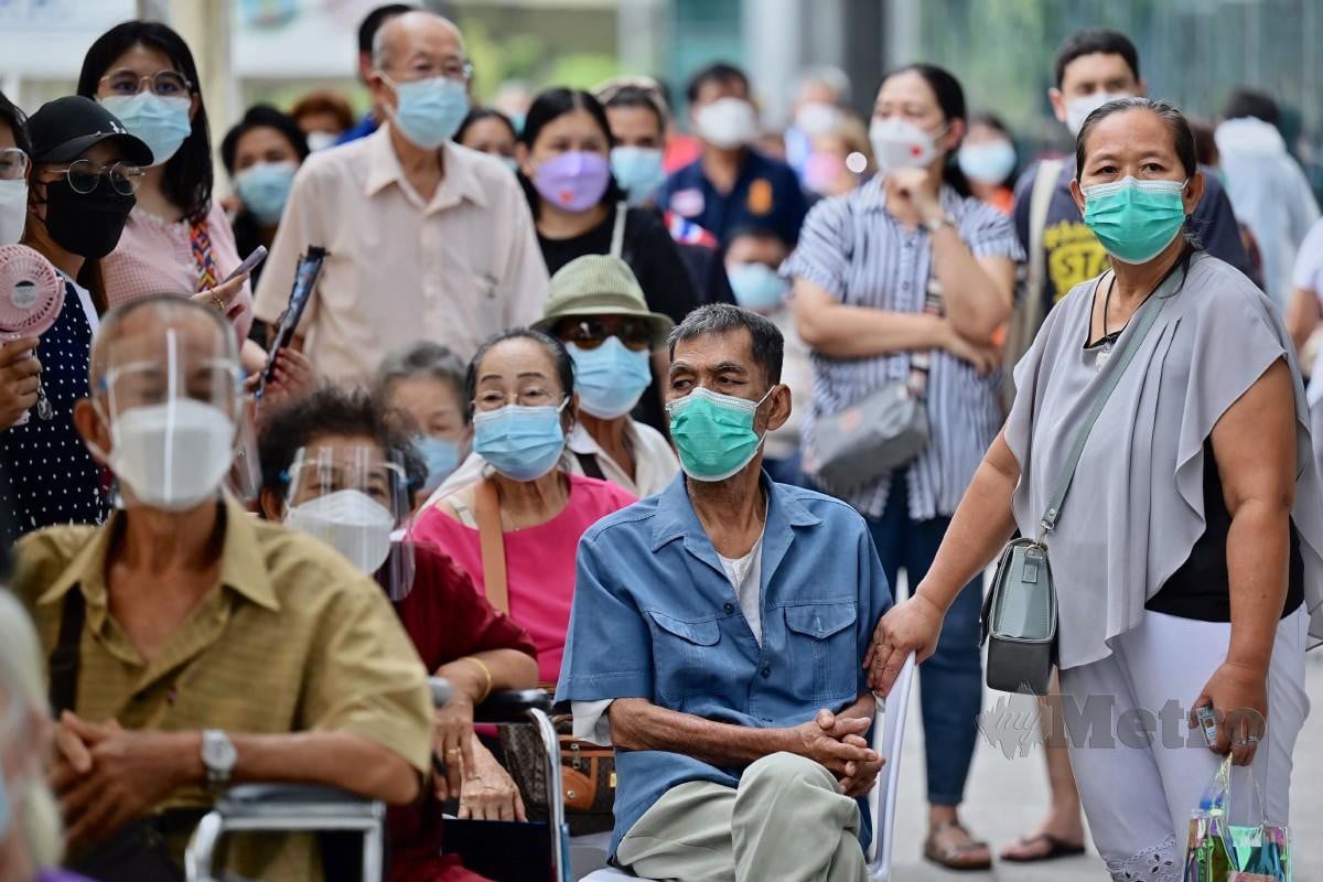 Warga emas dan pengiring mereka menanti giliran untuk mendapatkan suntikan vaksin Covid-19 di Bangkok. FOTO AFP