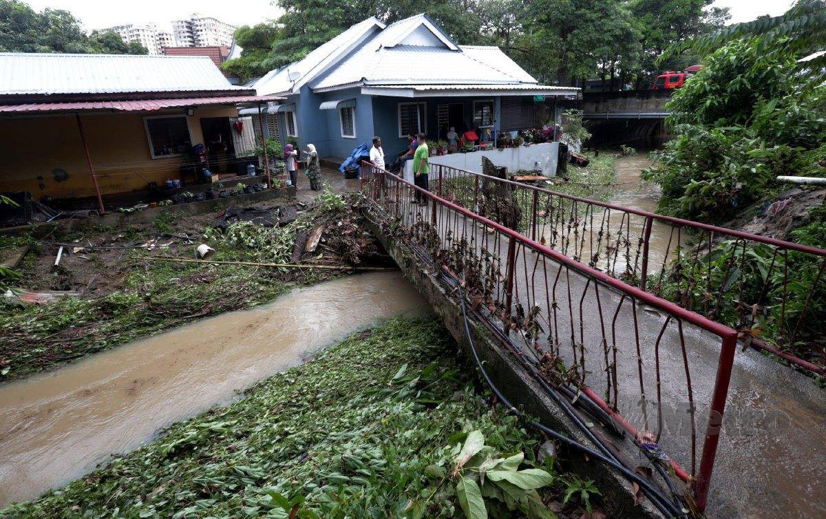 PARAS air Sungai Bayan Lepas melepasi pagar titi semasa kejadian banjir kilat di Jalan Kampung Bukit di sini. FOTO Danial Saad