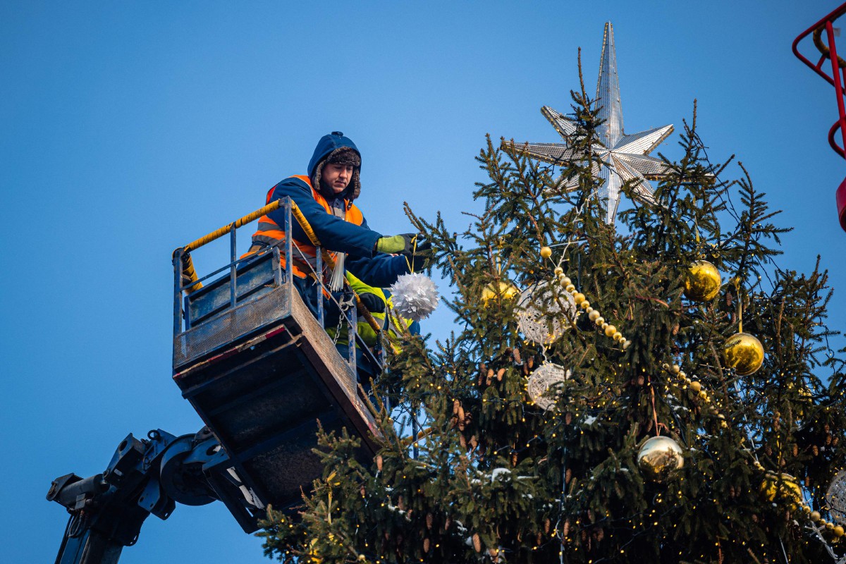 Seorang pekerja menghias pokok setinggi 28 meter di Sobornaya Square di Moscow. - FOTO AFP