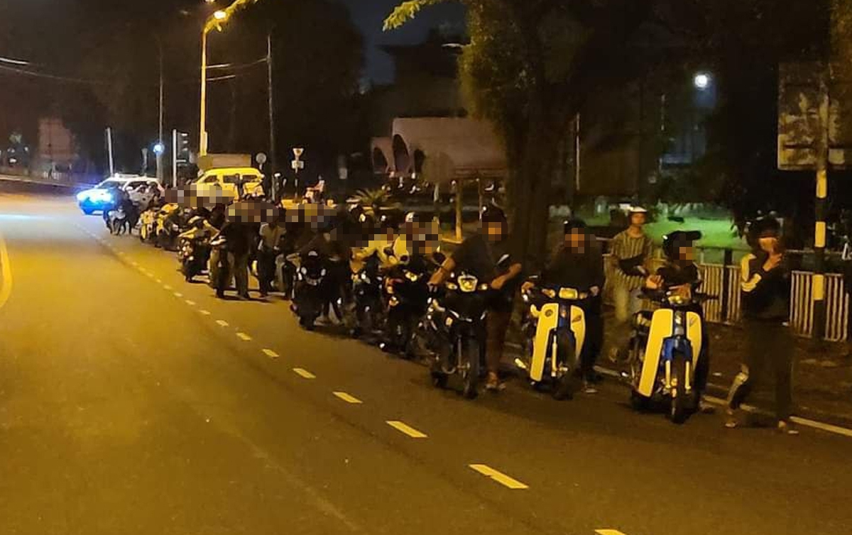 SEBAHAGIAN penunggang motosikal yang ditahan polis kerana disyaki terbabit dalam Op Samseng Jalanan terpaksa mengusung motosikal masing-masing. FOTO ihsan PDRM
