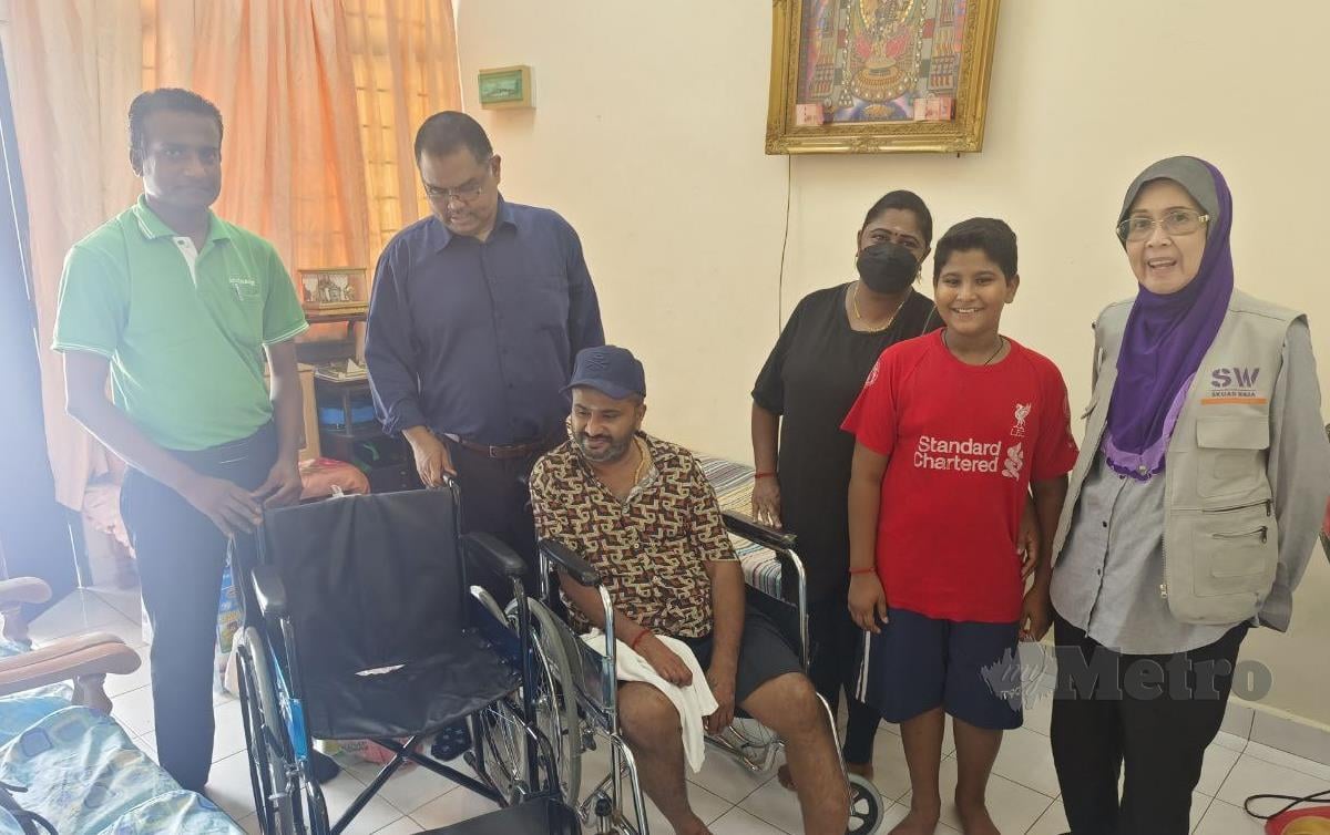 NAGARAJAN (berkerusi roda) dan keluarganya menerima kunjungan daripada Pengurus Besar Pasaraya Econsave Cash And Carry. FOTO Mary Victoria Dass