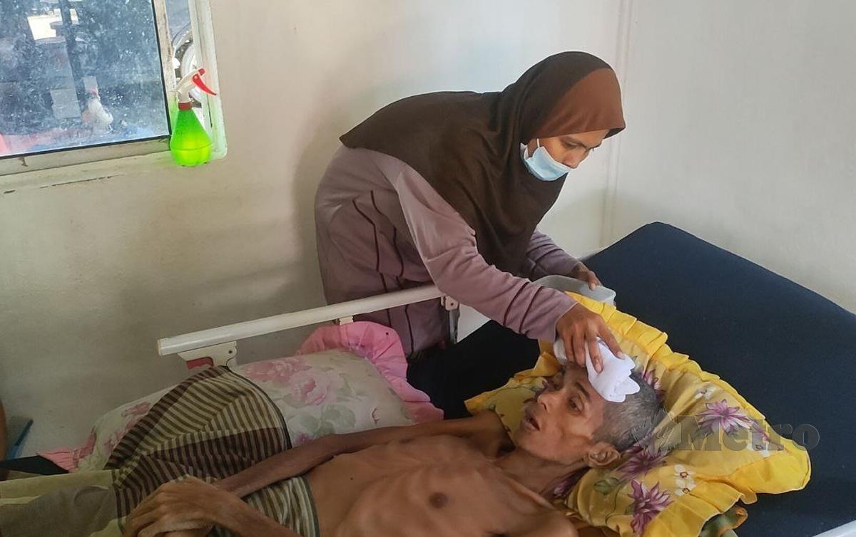 NOR Aza Hamzah mengelap kepala suaminya, Mohd Asri Zakaria yang menghidap kanser buah pinggang tahap empat. FOTO Zuliaty Zulkiffli