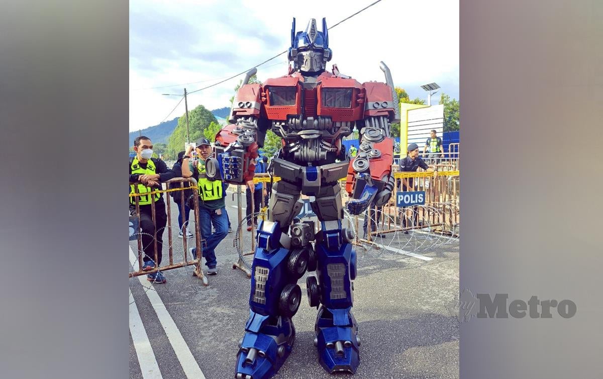 KEHADIRAN penyokong yang lengkap berpakaian robot watak Optimus Prime dalam filem Transformers seberat 30kg mengujakan orang ramai, hari ini. FOTO Aminah Yusof