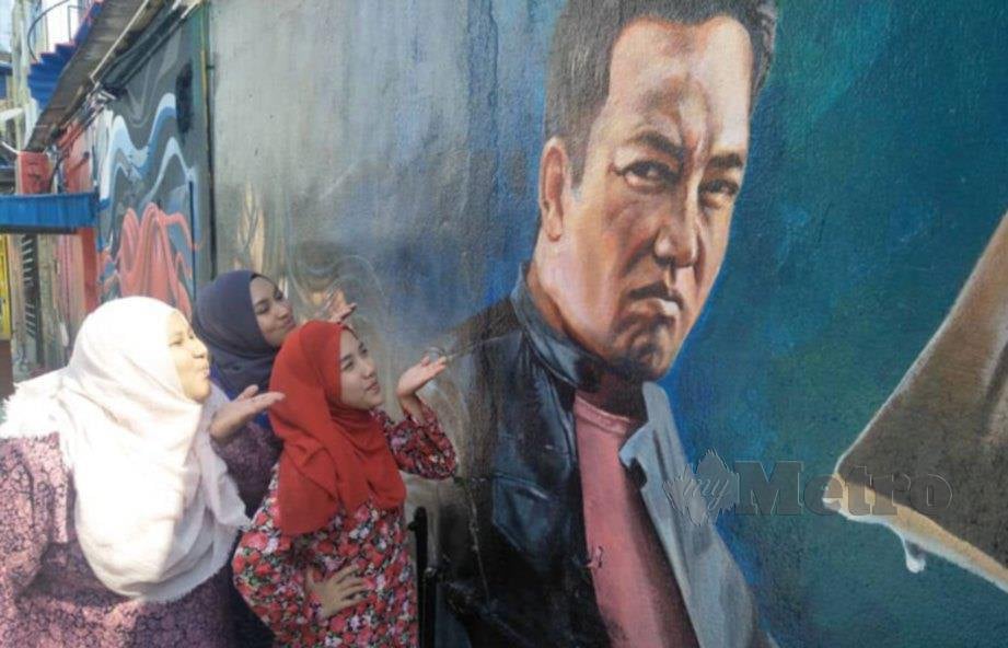 BEBERAPA pengunjung yang tidak melepaskan peluang bergambar pada lukisan mural di belakang sebuah bangunan di Jalan Penjara. FOTO Dziyaul Afnan Abdul Rahman