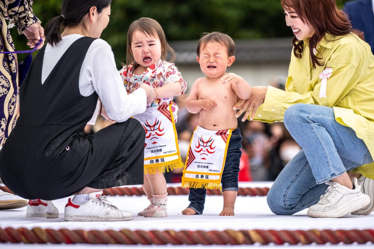 Dua bayi dipegang ibu mereka dalam ‘pertarungan’ sumo tangisan di Tokyo. - FOTO AFP