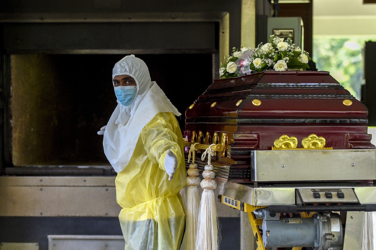 Kakitangan kawasan perkuburan menyiapkan keranda yang membawa White di Colombo. - FOTO AFP