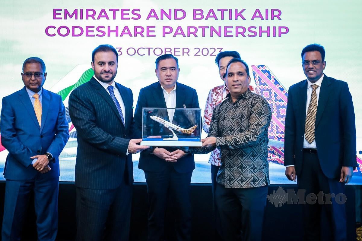 Loke (tengah) menyaksikan pertukaran replika pesawat antara Emirates dan Batik Air sempena pemeteraian perjanjian perkongsian kod kedua-dua syarikat penerbangan. - FOTO Asyraf Hamzah
