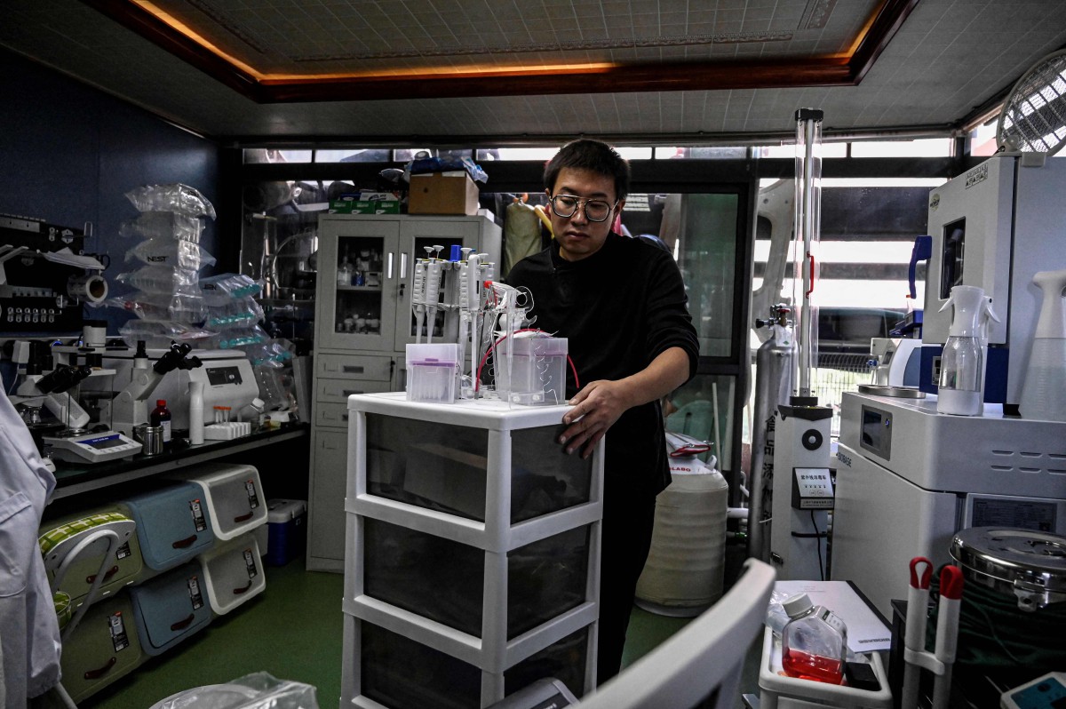 Xu Wei menyusun peralatan perubatan di makmal yang terletak di kediamannya di Kunming, wilayah Yunnan, China. - FOTO AFP