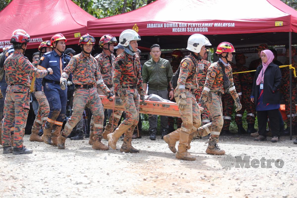 ANGGOTA bomba membawa keluar mayat mangsa yang terlibat dalam kejadian tanah runtuh berhampiran tapak perkhemahan Father Organic Farm Jalan Genting, Batang Kali. FOTO Aswadi Alias