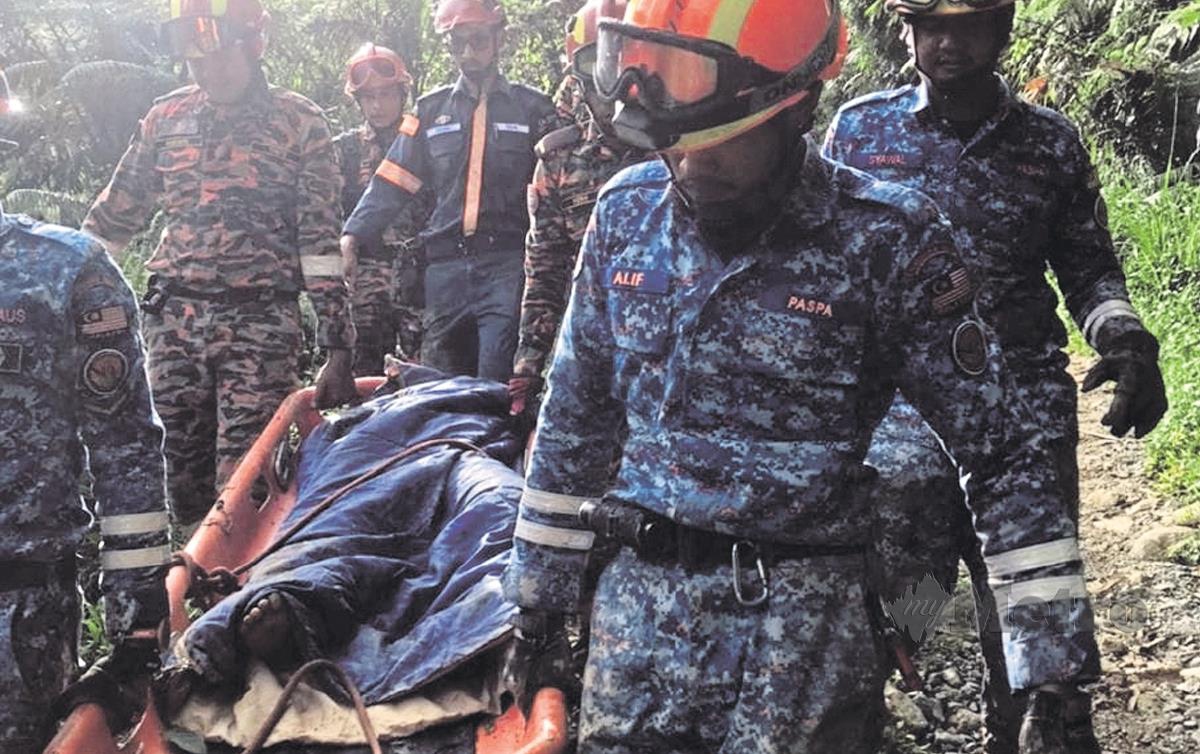 PASUKAN penyelamat membawa jasad seorang  mangsa yang terkorban dalam kejadian tanah runtuh di tapak perkhemahan di Batang Kali.