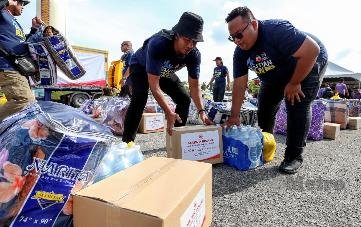 ANGGOTA Pertubuhan Perpaduan Media Malaysia memeriksa  sumbangan barangan keperluan asas untuk penerima mangsa banjir yang terjejas. FOTO Nik Abdullah Nik Omar