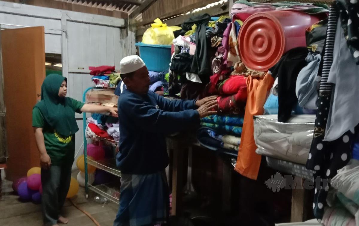 RAJA Sulaiman menunjukkan barangan yang terpaksa dialih ke tempat lebih tinggi di dalam rumahnya bagi mengelak ditenggelami banjir. FOTO Nazdy Harun
