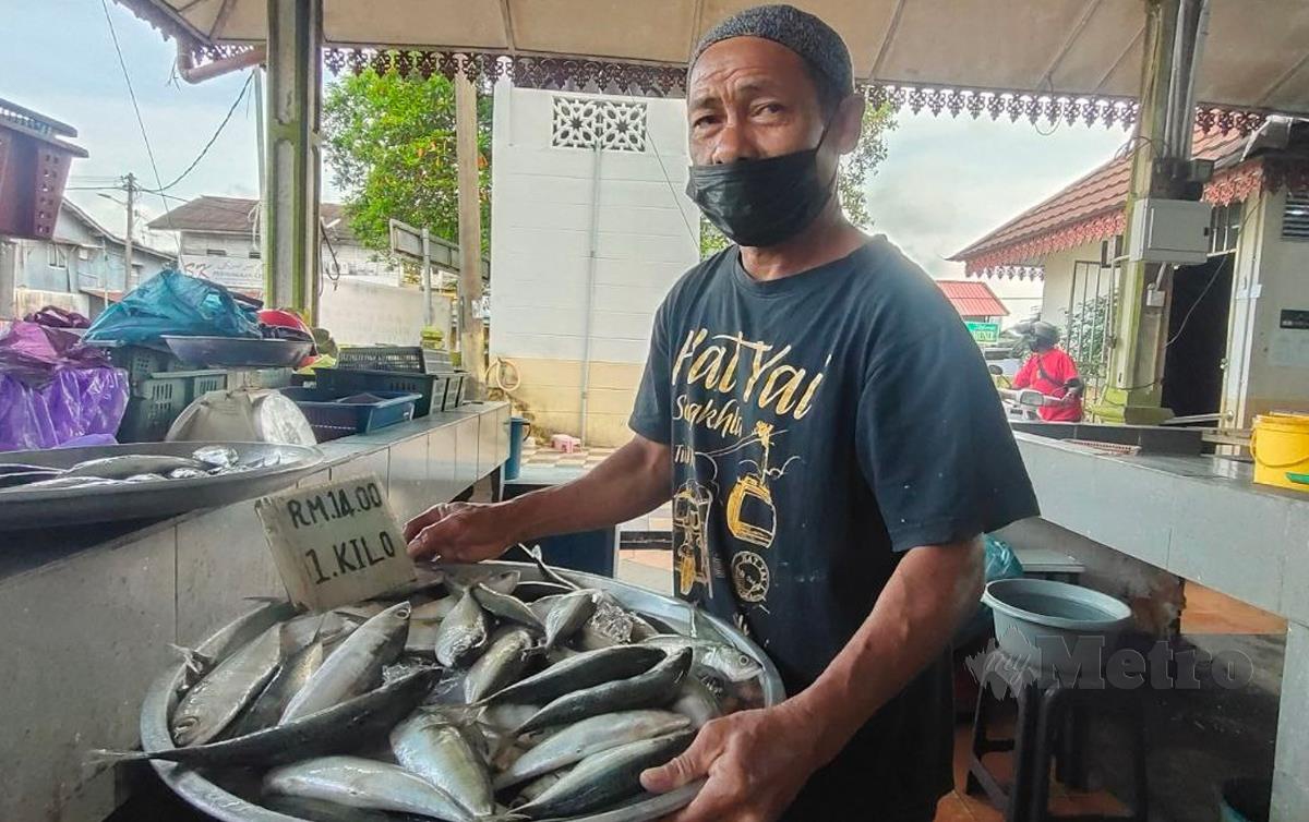 MAT Janin menunjukkan ikan yang dijual di kedainya di Pasar Kubang Pasu, di sini. FOTO Syaherah Mustafa