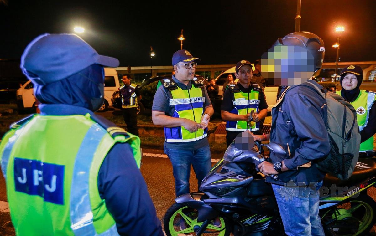 MOHD Zaki Ismail membuat pemeriksaan terhadap penunggang motorsikal pada Operasi Penguatkuasaan Khas Motorsikal JPJ Wilayah Persekutuan Kuala Lumpur. FOTO Aizuddin Saad