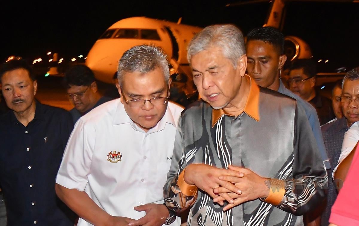 DATUK Dr Ahmad Zahid Hamidi membincangkan sesuatu dengan Setiausaha Persekutuan Sabah, Datuk Makhzan Mahyuddin. FOTO Adam Arinin
