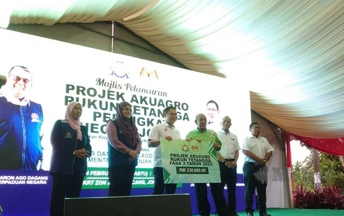 LING Tian Soon menyerahkan replika cek bernilai RM 230,000 sumbangan Kerajaan Negeri Johor kepada wakil KRT  bagi 20 projek Akuagro RT baharu pada tahun ini di Taman Kota Masai di sini hari ini. FOTO Mary Victoria Dass