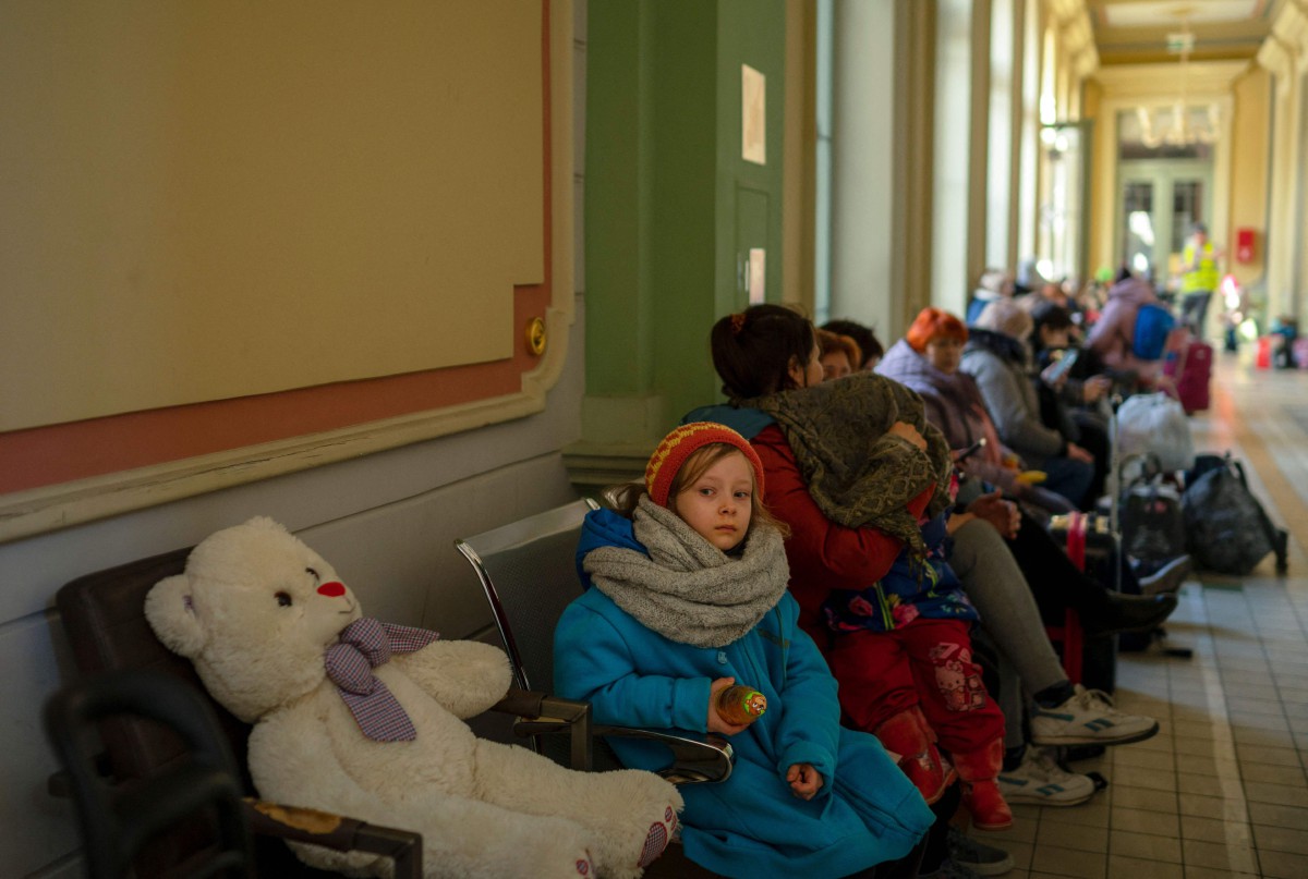 Seorang kanak-kanak yang kini bergelar pelarian Ukraine duduk di stesen kereta api di Przemysl, Poland. - FOTO AFP