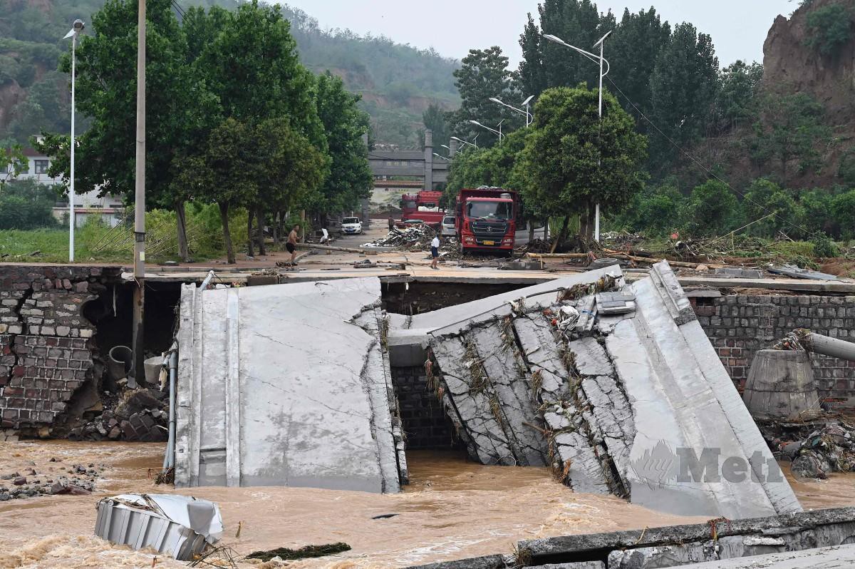 Jalan yang rosak akibat banjir dan tanah runtuh di bandar Gongyi di Zhengzhou, wilayah Henan, China. - AFP