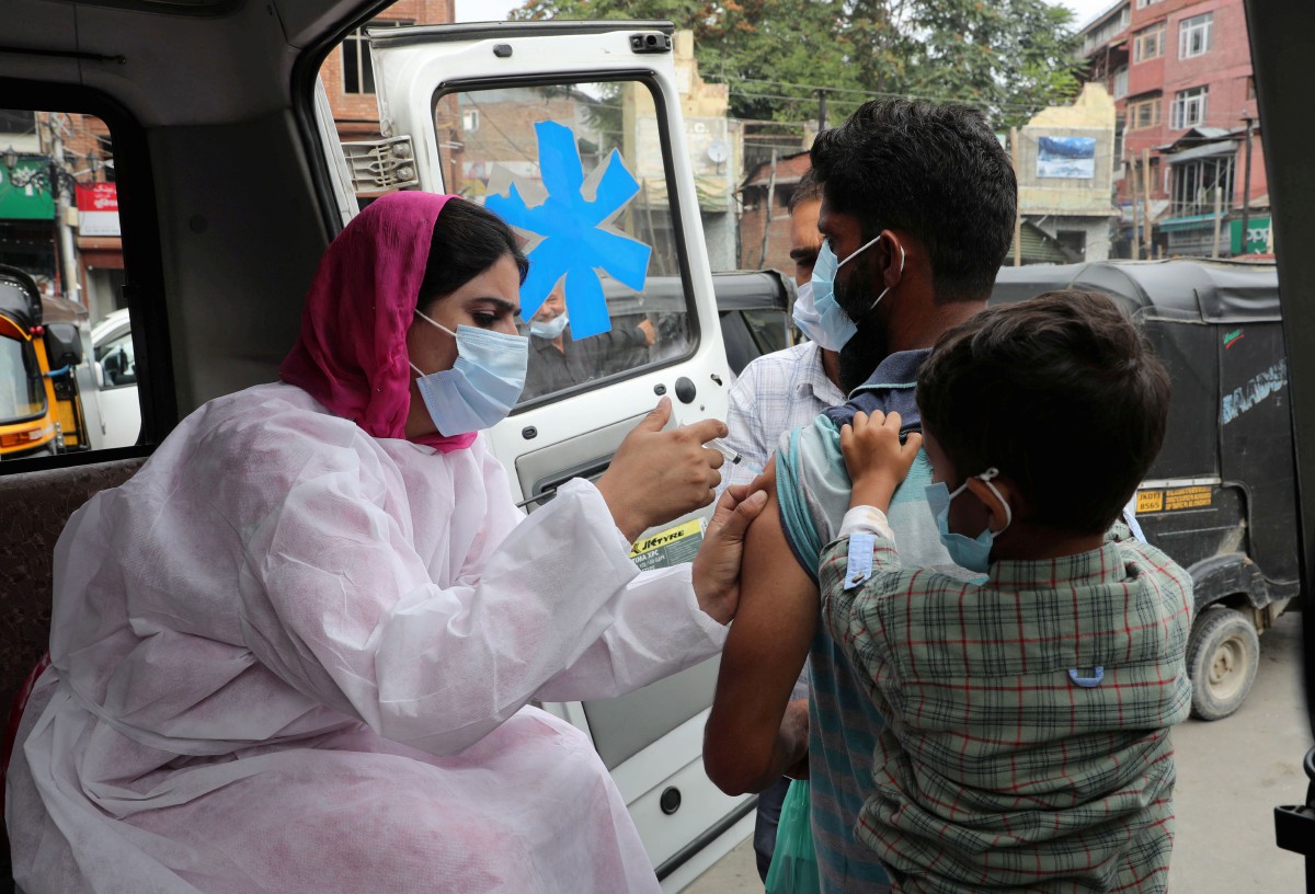 Seorang lelaki menerima suntikan vaksin Covid-19 di Srinagar, Kashmir, India. - FOTO EPA