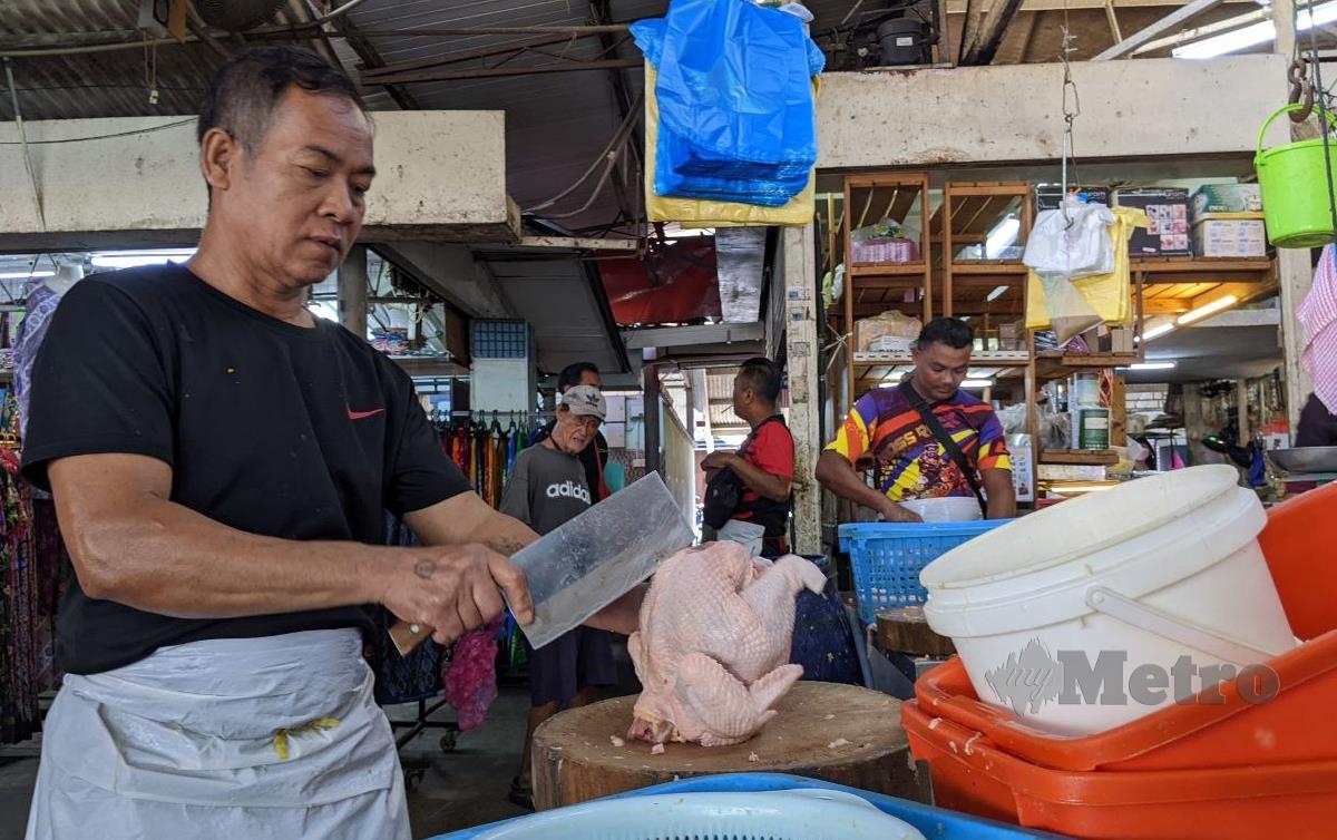 PENIAGA ayam di pasar awam terpaksa mengenakan caj perkhidmatan antara RM1.10 hingga RM1.90 berikutan kenaikan kos penghantaran yang dikenakan pembekal. FOTO Zuhainy Zulkiffli