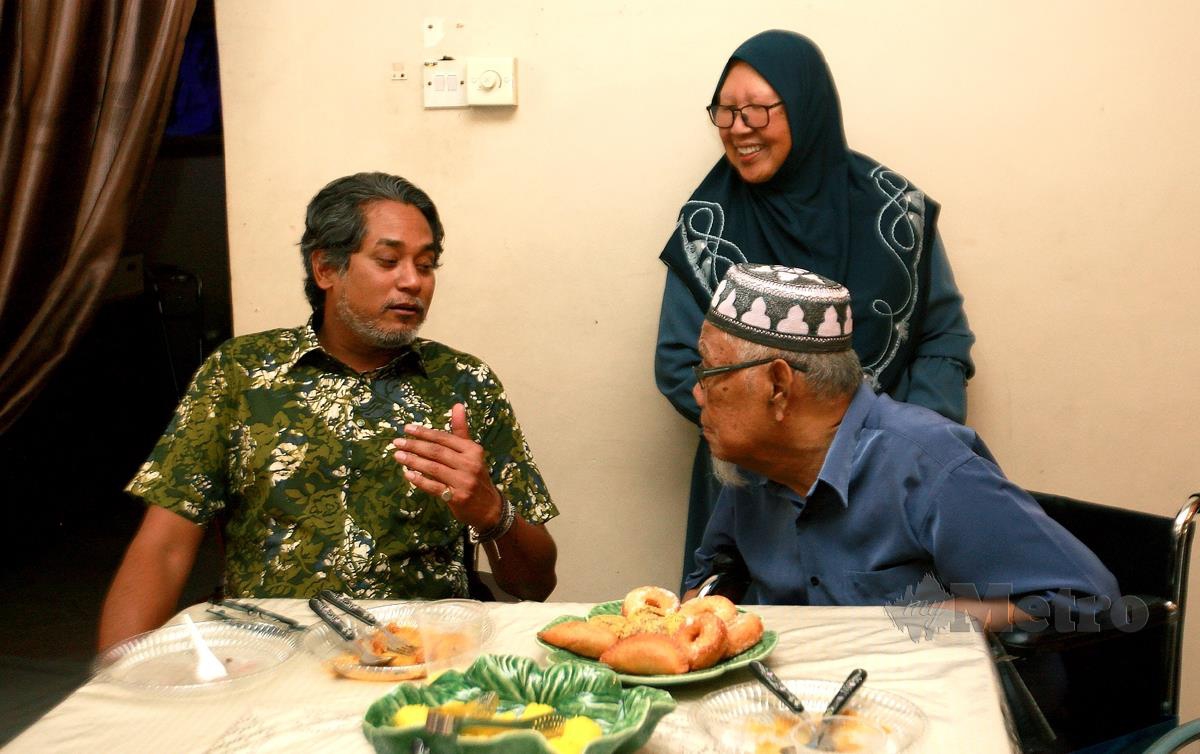 KHAIRY Jamaluddin (kiri) beramah mesra bersama Rapiei Hassan (berkerusi roda) ketika program turun padang penyampai stesen radio Hot FM di Taman Sri Andalas, Klang. FOTO Faiz Anuar