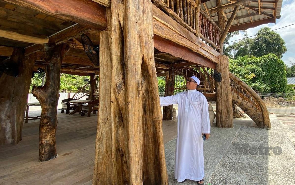 MOHD Fikri menunjukkan tiang masjid yang dibina menggunakan kayu tembesu. FOTO Hazira Ahmad Zaidi