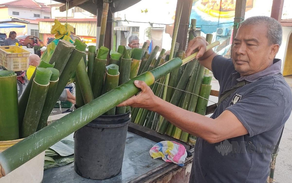 AZMAN Hassan tidak pernah lokek berkongsi ilmu tentang cara memasukkan daun pisang atau lerek ke dalam buluh lemang. FOTO Rosman Shamsudin