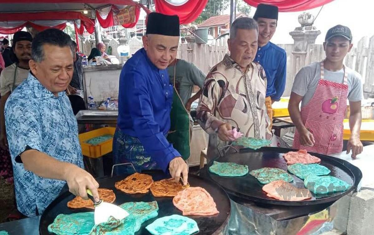 AHMAD (dua kanan), Mohd Sabri (dua kiri) dan Ahmad Razif (kiri) mengoreng roti canai empat warna pada Majlis Rumah Terbuka Aidilfitri UMNO Bahagian Kuala Terengganu, hari ini. FOTO Baharom Bakar