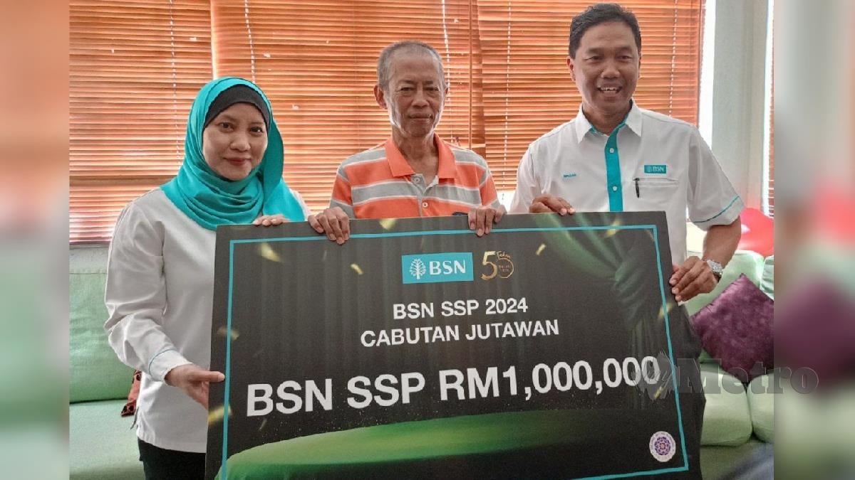 Pengarah BSN Perak, Mazlan Mat Jalil (kanan) menyerahkan replika cek RM1 juta kepada Mohd Nazri (tengah) yang memenangi Cabutan Jutawan Bank Simpanan Nasional Sijil Simpanan Premium (BSN SSP) yang ke-96. FOTO MUHAMAD LOKMAN KHAIRI.