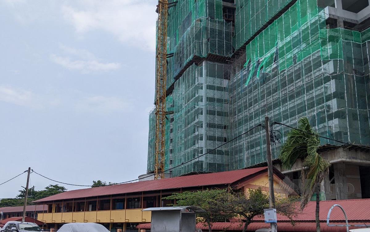 PEMBINAAN bangunan setinggi 42 tingkat berhampiran sekolah di Sungai Nibong, di sini, mendatangkan kegusaran kepada penduduk dan ibu bapa murid. FOTO Zuhainy Zulkiffli