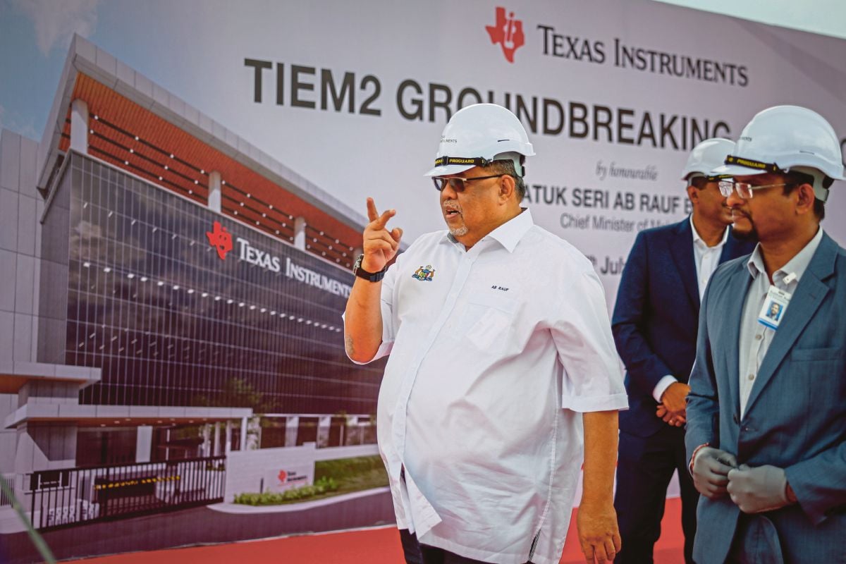RAUF Yusoh (kiri) ketika hadir pada majlis pecah tanah kilang Texas Instruments(TI) Incorporated di Batu Berendam, hari ini. FOTO Bernama