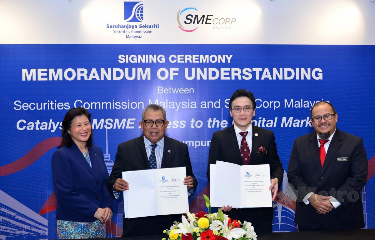 AWANG Adek (dua dari kiri) dan Rizal (dua dari kanan) pada majlis menandatangani MoU antara SC dan SME Corp.