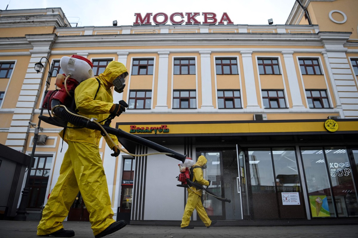 Anggota keselamatan Rusia menyembur disinfektan di stesen kereta api Savelovsky di Moscow. - FOTO AFP