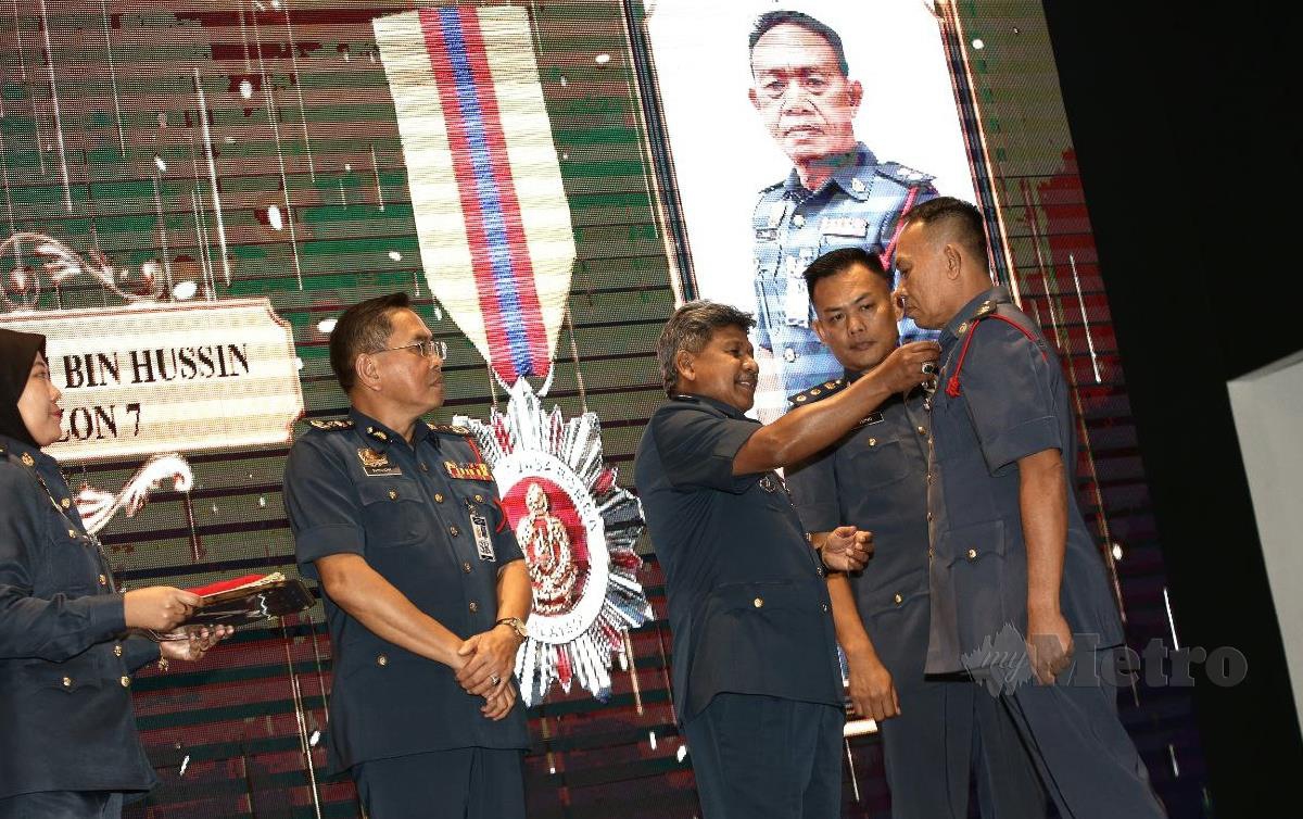 WAHAB Mat Yasin, dan Khirudin Drahman menyampaikan Anugerah Perkhidmatan Cermerlang di Raia Hotel Kuching. FOTO Nadim Bokhari