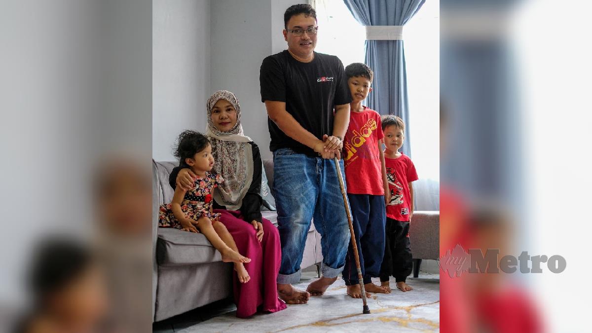 Nik Nor Haziera Nik Sin bersama suaminya Mohd Hafizi Md Noor yang merupakan orang kurang upaya sejak kecil bersama anaknya ketika ditemui dikediamanya di Putra Perdana. FOTO HAZREEN MOHAMAD