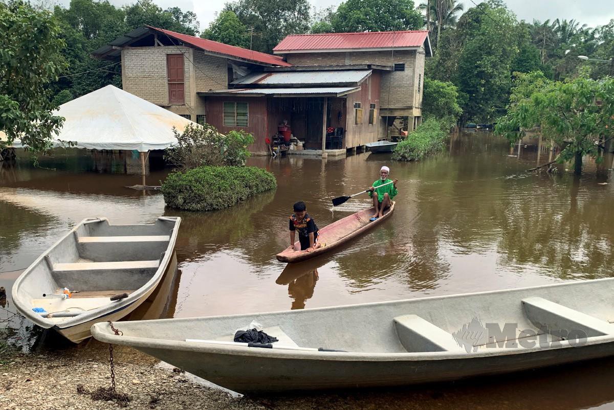 Hujan lebat sejak beberapa hari lalu menyebabkan rumah penduduk di Kampung Tersang dekat Rantau Panjang di sini, mulai dinaiki air. FOTO BERNAMA