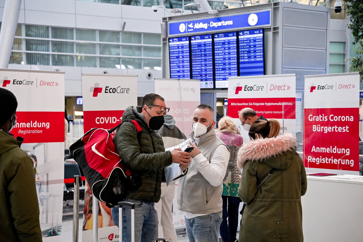 Pelawat di Lapangan Terbang Antarabangsa Duesseldorf, Jerman melihat maklumat berkaitan penerbangan mereka. Varian baharu yang dikesan di Afrika Selatan menimbulkan kebimbangan antarabangsa. - FOTO EPA