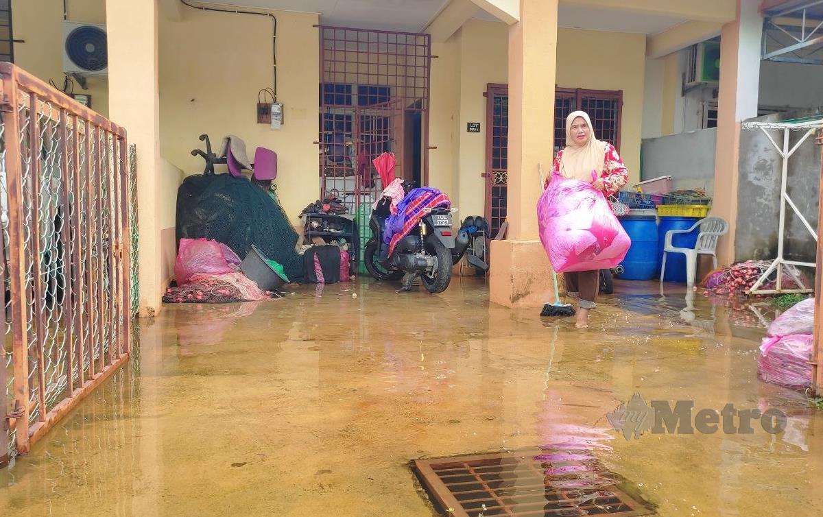MAZNAH memindahkan barang selepas rumahnya di Taman Sri Intan, Kuala Besut turut dinaiki air banjir dan air termenung masih belum surut . FOTO Nurul Fatihah Sulaini