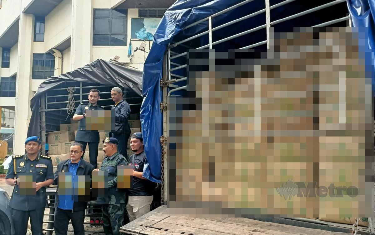 AZMAN Ismail (tengah) menunjukkan minyak masak yang dirampas dari dua lori yang ditahan di Tunjong sert Salor, pagi semalam. FOTO Siti Rohana Idris