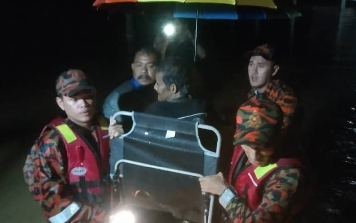 RADZI diselamatkan anggota bomba dari Balai Bomba dan Penyelamat Rantau Panjang selepas kediamanya di Kampung Gual Mekong, dilanda banjir, semalam. FOTO ihsan BOMBA