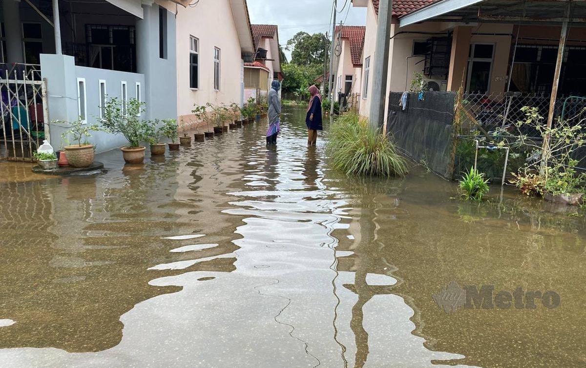 PENDUDUK di kawasan perumahan Taman Seri Nilam, Limbat terpaksa mengharungi air banjir termenung sejak dua minggu lalu. FOTO Hazira Ahmad Zaidi