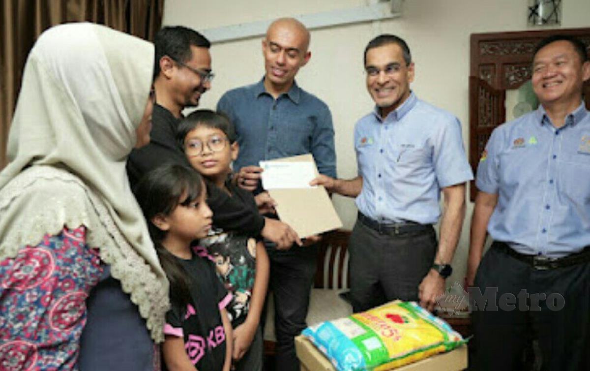 Mohammed Azman (dua kanan) menyampaikan sumbangan kepada keluarga arwah Siti Nor Hafiza