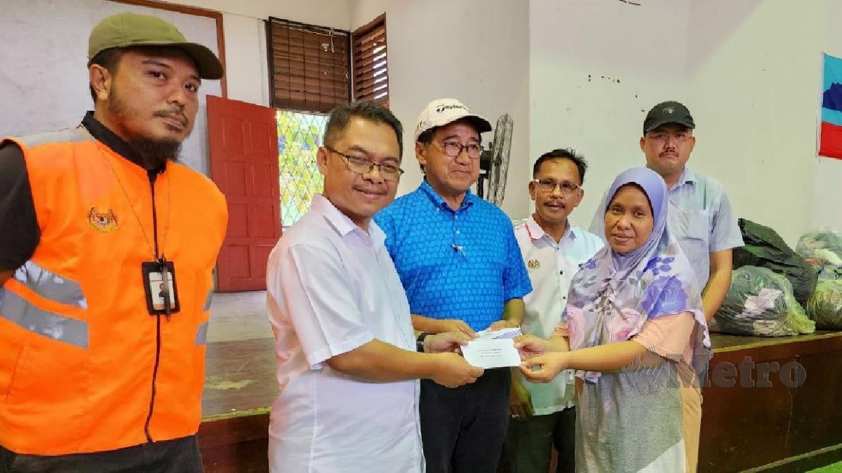  Mustapha memberi sumbangan berupa wang tunai kepada mangsa kebakaran di Dewan Serbaguna Kampung Likas, Kota Kinabalu. FOTO JUWAN RIDUAN