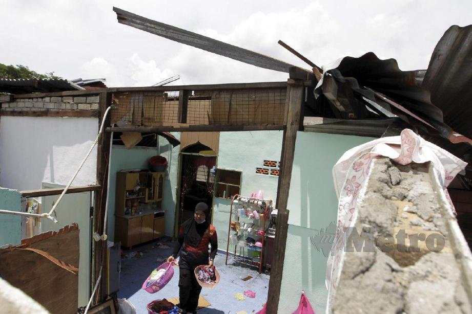 SITI Asiah nyaris cedera selepas bumbung bahagian hadapan rumahnya runtuh manakala bumbung dalam bilik dan bahagian dapur telah diterbangkan ribut. FOTO Danial Saad