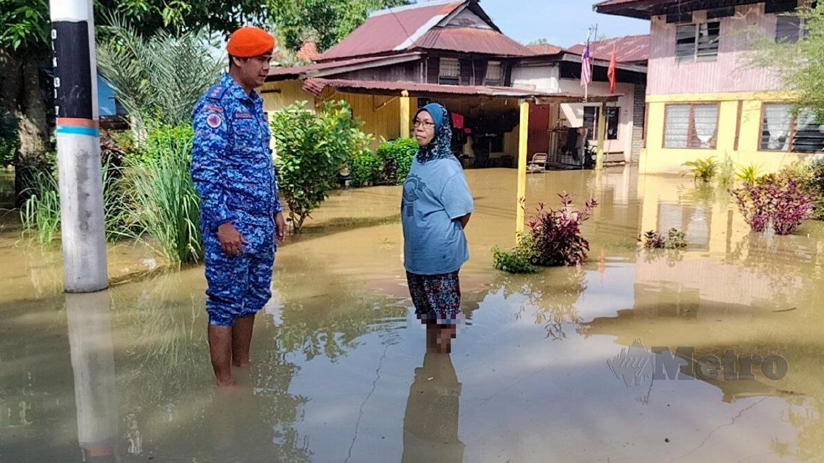 Kapten (PA) Saifuddin Abdullah menasihatkan penduduk Kampung Seberang Anak Bukit, Nisa Abdul selepas rumahnya di rumahnya dinaiki air. FOTO ZULIATY ZULKIFFLI