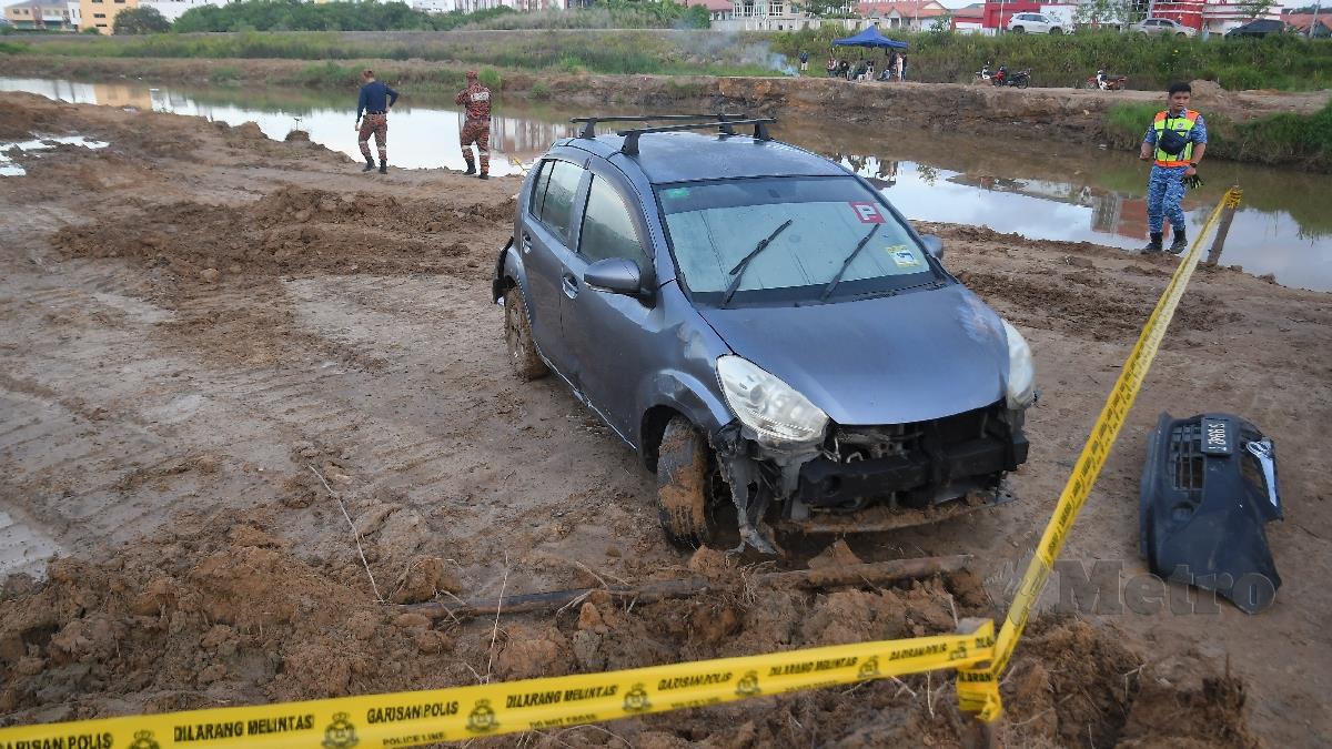 KERETA yang terjatuh ke sungai Kampung Imbahan, Putatan, kelmarin manakala pencarian mangsa disambung hari ini. FOTO MOHD ADAM ARININ