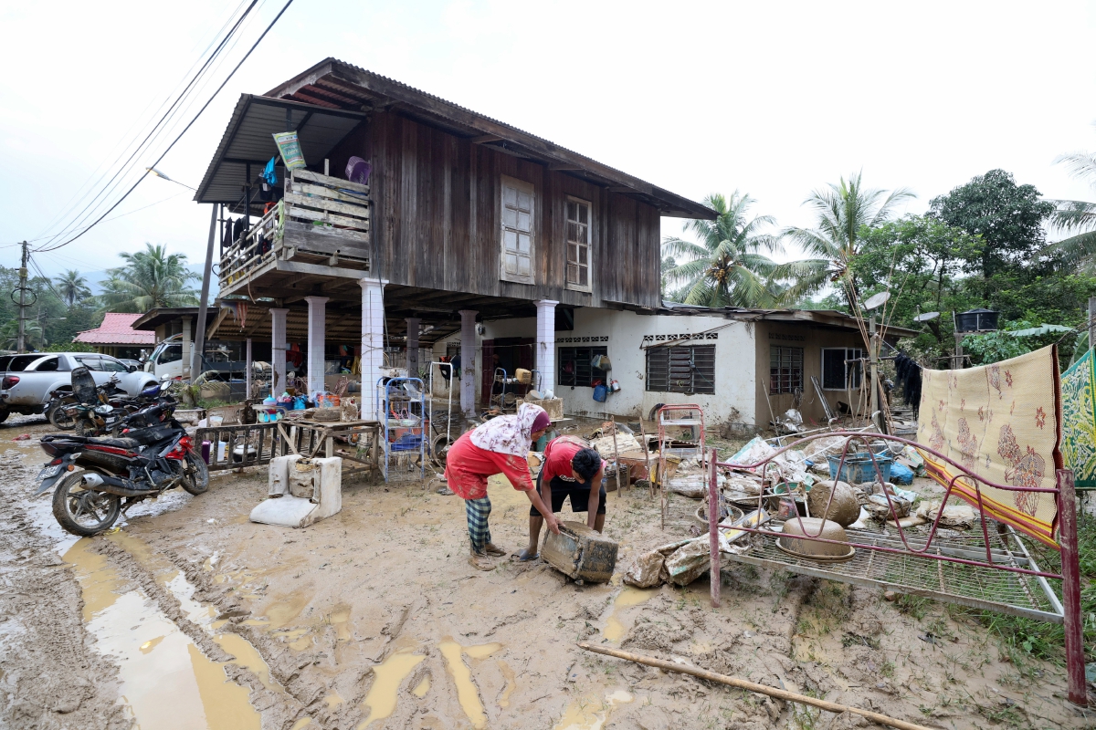 PENDUDUK  di Kampung Shukor melakukan kerja-kerja pembersihan selepas kediaman mereka dilanda banjir lumpur pada Khamis lepas. FOTO Bernama